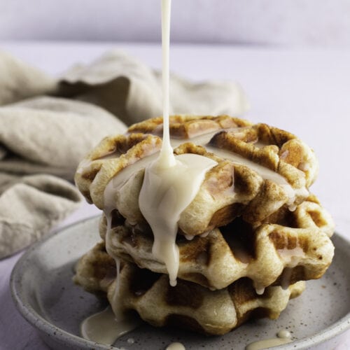 Pouring Syrup Over a Cinnamon Roll Waffles on a Plate 500x500 1